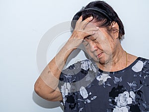 Old senior woman suffering and covering face with hands in headache and deep depression. emotional disorder, grief and desperation