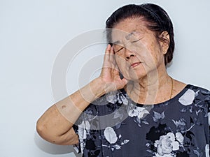 Old senior woman suffering and covering face with hands in headache and deep depression. emotional disorder, grief and desperation