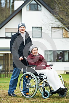 Old senior woman in wheelchair with careful son