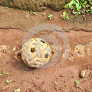 Old sepak takraw ball (Rattan ball) on soil background