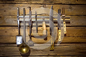 Old set of kitchenware hanging on wooden wall