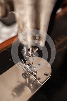 Old sewing machine stands on the table at home ready to work and sew.