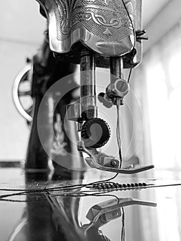 Old sewing machine stands on the table at home ready to work and sew.