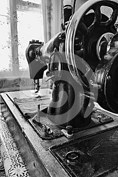 Old sewing machine stands on the table at home ready to work and sew.