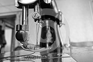 Old sewing machine stands on the table at home ready to work and sew.