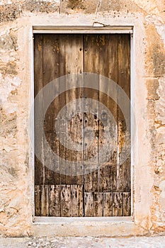 Old shabby brown wooden front door of rustic house