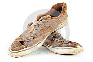 Old shabby dirty sneakers on a white background. Worn out shoes