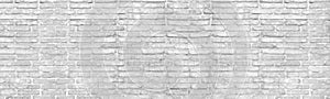 Old shabby distressed white brick wall wide texture. Aged rough whitewashed masonry. Light gray grunge background