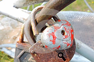 An old shabby heart-shaped lock on the railing opened