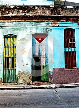 Old shabby house in Central Havana painted with the Cuban flag a