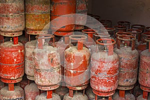 A old shabby red propane gas cylinders are in warehouse