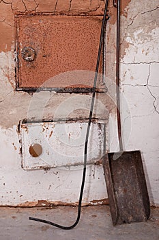 Old shabby and rusty metal door of brick furnace in country house