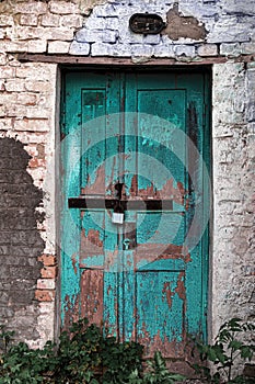 Old shabby wall facade with wooden door.