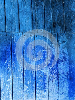 Old shabby wooden planks with cracked blue color paint. Rural country background