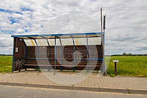 An old  shed at a bus stop on a country road somewhere in Poland