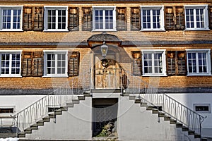 Old shingle house facade with exterior shutters and staircase