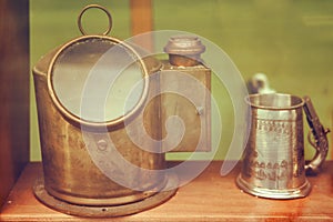 Old ship deck lamp and metal mug, close-up