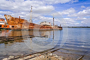 Old ship run aground and rusting in the shore.