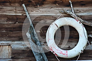 Old ship's rudder against worn wooden background