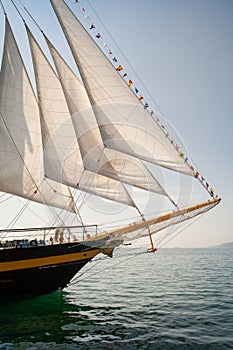 Old ship with white sales, sailing in the sea