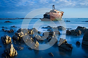 Old shipwreck long exposure on the rocks sunse