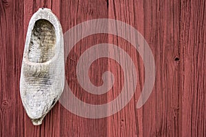 An old shoe in front of a typival scandinavian building with falu red photo