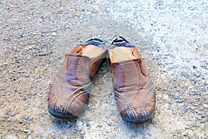 Old shoes leather worn out On floor road background