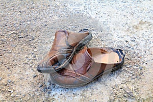 Old shoes leather worn out On floor road background