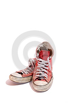 Old shoes, red with white, dirty and worn out isolated on white background.