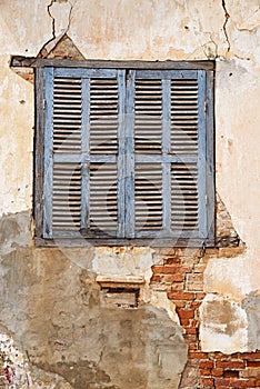 Old Shuttered Window In Cracked Peeling Wall