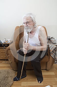 Old sick lonely man in the armchair at home