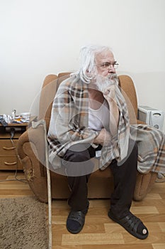 Old sick lonely man in the armchair at home