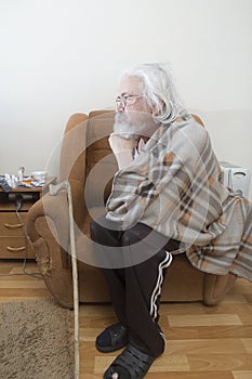 Old sick lonely man in the armchair at home