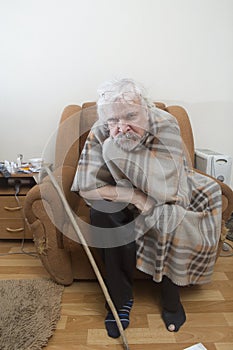 Old sick lonely man in the armchair at home