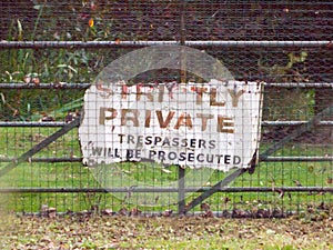 Old sign on gate strictly private trespassers will be prosecuted