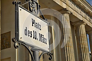 Old signboard with caption Platz Des 18. Marz written in old German font as a symbol of central Berlin