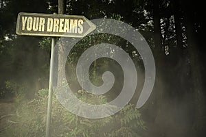 Old signboard with text your dreams near the sinister forest