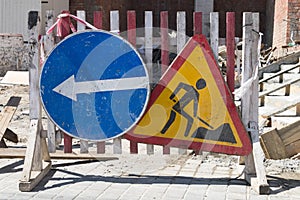 Old signs warning of construction work and detour.