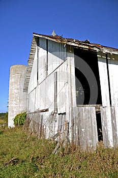 Old silo and abandoned white barn