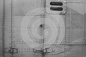 Old silver metal surface of the aircraft fuselage with rivets. Fuselage detail view. Airplane metallic fuselage detail