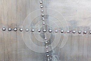 Old silver metal surface of the aircraft fuselage with rivets. Iron plate,steel sheet texture,pattern and background.