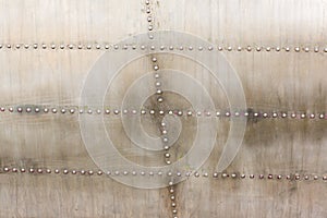 Old silver metal surface of the aircraft fuselage with rivets. Iron plate,steel sheet texture,pattern and background.