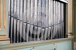 Old, silver organ pipes in a church used for playing sacred music. Many air pipes, sound tubes in the cathedral