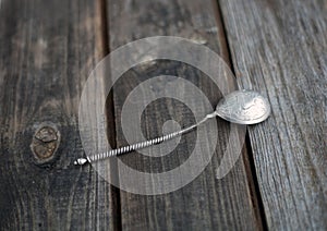 Old silver spoon on wooden table
