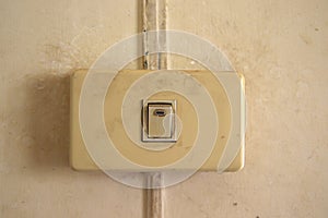 Old Single white light switch on wall,old Single Electrical on off switch that have been used for a long time on the white wall