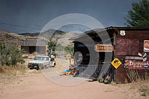 Old  a sixth generation Ford F-Series tow truck near a mechanic shop on the desert road