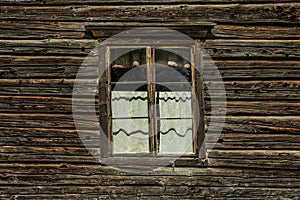 Old skewed window in a timber wall