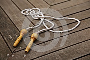 An old skipping rope on a wooden deck. Exercising at home concept image