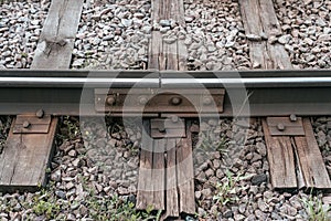 Old sleepers, in city there is a tram line. In nature, a wet wooden board. Coupling of metal rails.