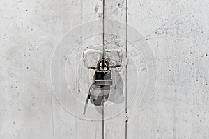 An old and slightly rusty lock hangs on an iron gate